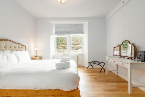 um quarto branco com uma cama branca e uma secretária em Murray Place - Central 2 Bed Apt em St. Andrews