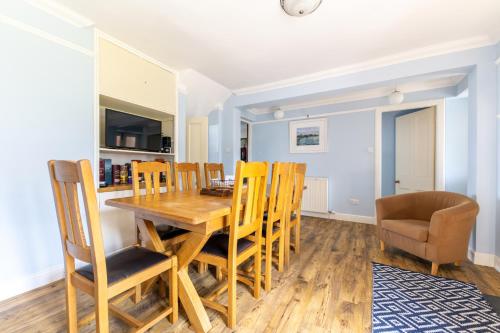 uma cozinha e sala de jantar com uma mesa de madeira e cadeiras em Seaview House - A Traditional Home by the Beach em Nairn