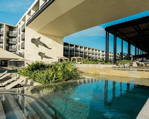 a swimming pool in front of a building at Grand Hyatt Playa del Carmen Resort in Playa del Carmen
