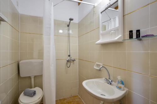 a small bathroom with a toilet and a sink at Villa Kapasa in Mathés