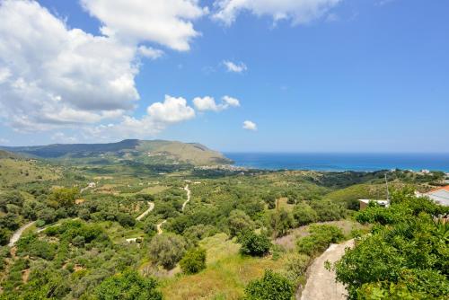 a view of a valley with the ocean in the background at Villa Kapasa in Mathés