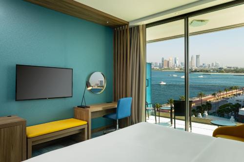 a hotel room with a bed and a large window at Aloft Palm Jumeirah in Dubai