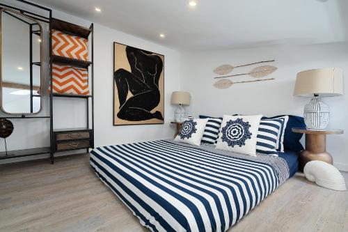 a bedroom with a bed with blue and white pillows at Tiny Home in by Portimao Promenade Pier in Historic Quarter in Portimão