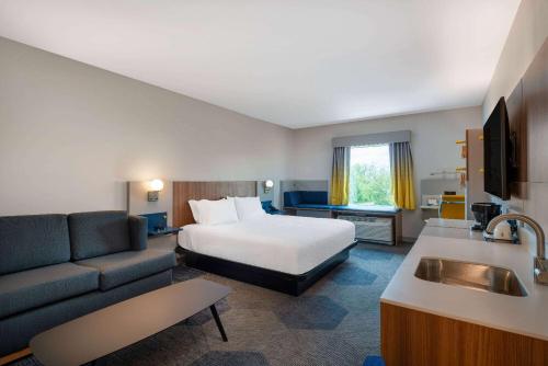 a hotel room with a bed and a couch at Microtel Inn & Suites by Wyndham Winchester in Winchester