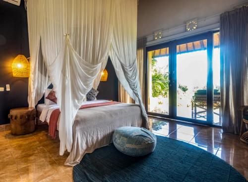 a bedroom with a canopy bed and a large window at Pelangi Villas Sidemen in Sidemen