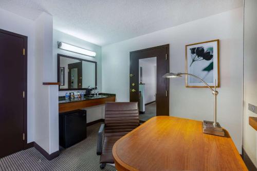 a room with a table and chairs and a desk at Wyndham Garden Kansas City Airport in Kansas City
