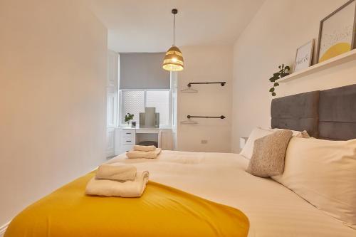 1 dormitorio con 1 cama grande y toallas. en 5 Roker Terrace - Seaview apartments en Sunderland