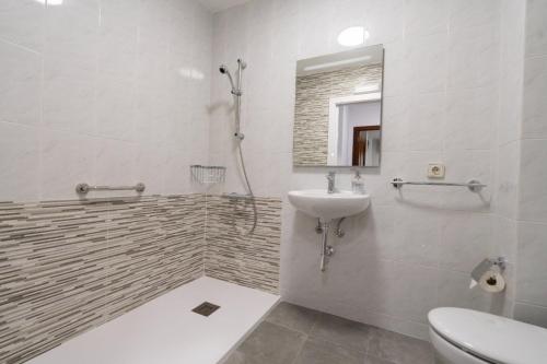 y baño con aseo, lavabo y ducha. en Pension O Camiño Milladoiro, en Amés