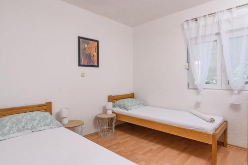 1 dormitorio con 2 camas y ventana en Apartment Planikovica en Trogir