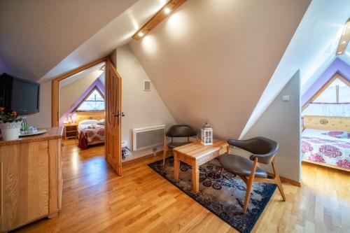 a room with a desk and two chairs and a bedroom at Butorowy Dwór in Kościelisko