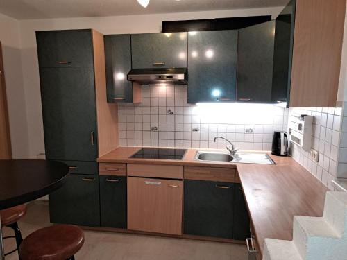 uma cozinha com armários castanhos, um lavatório e um balcão em Apartment Yasmin - MHO159 by Interhome em Schwendau