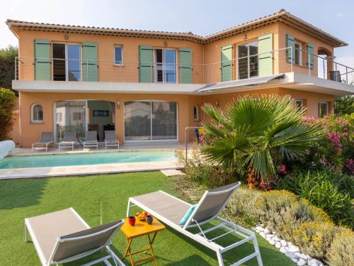 une villa avec une piscine et deux chaises longues dans l'établissement Villa Plein Sud by Interhome, à Saint-Aygulf