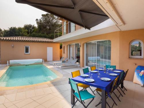 un patio avec une table et des chaises à côté d'une piscine dans l'établissement Villa Plein Sud by Interhome, à Saint-Aygulf