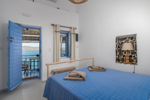 a bedroom with a blue bed and a view of the ocean at Blue Horizon Syrma in Klima