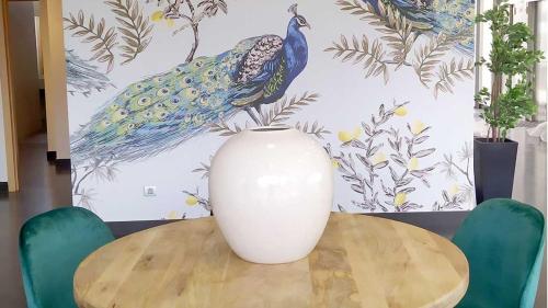 a white vase sitting on top of a wooden table at Alda Valladolid Sur in Valladolid