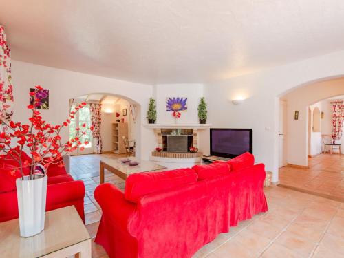 サント・マキシムにあるHoliday Home La Bastide Rose by Interhomeのリビングルーム(赤いソファ、テレビ付)