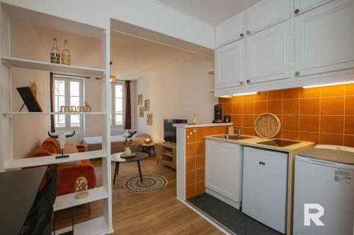 kuchnia z białymi szafkami i pomarańczowymi płytkami w obiekcie Ô Centre- Chaleureux - Fibre - Netflix w mieście Montargis