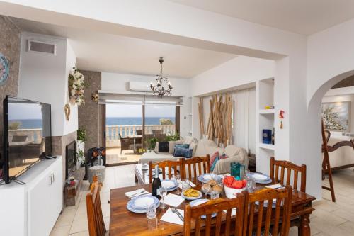 cocina y sala de estar con mesa y sillas en Villa Beach Heaven, en Pomos