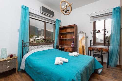 Un dormitorio con una cama azul con toallas. en Villa Beach Heaven, en Pomos