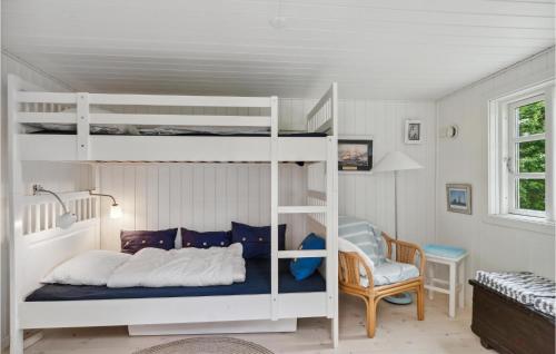 a bedroom with two bunk beds and a chair at 3 Bedroom Stunning Home In Dronningmlle in Dronningmølle