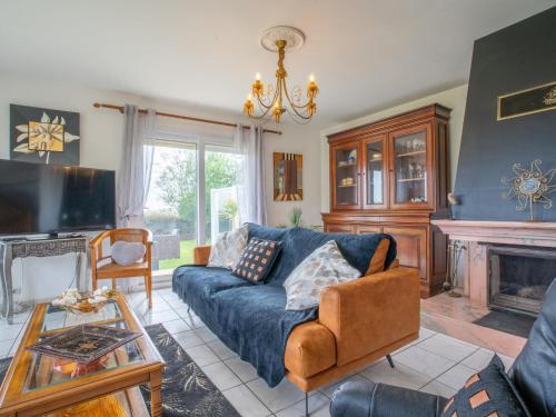 Una sala de estar con un sofá azul y una chimenea. en Holiday Home Ty Nevez by Interhome, en Sibiril