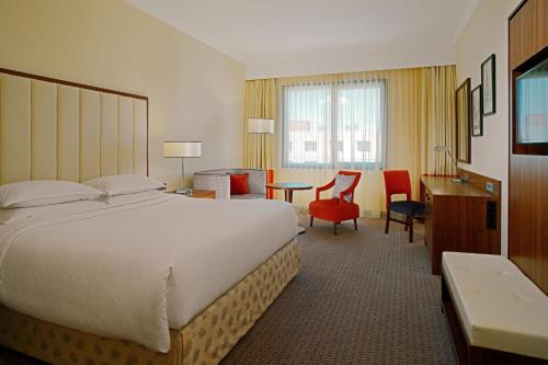 a hotel room with a large bed and a desk at Sheraton Zagreb Hotel in Zagreb