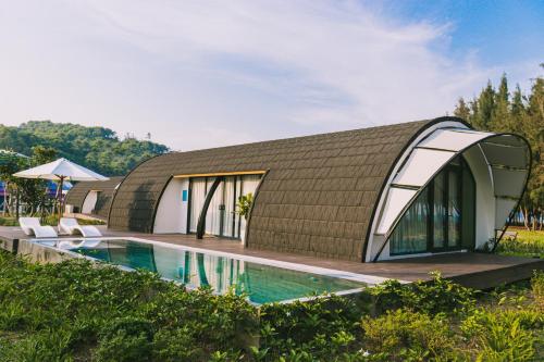 ein Haus mit Dachschräge und Pool in der Unterkunft Đầu Rồng Resort 