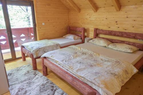 Hakuna Matata Lake House في يايتشه: غرفة نوم بسريرين في كابينة خشب