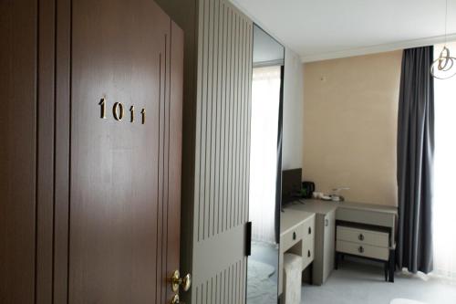 a room with a door with a desk and a mirror at All Elevens 11 Apartments in Bitola