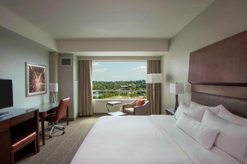 a hotel room with a bed and a desk and a window at The Westin Wilmington in Wilmington