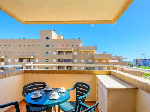 uma mesa azul e cadeiras numa varanda com um edifício em Apartment Sea View - Jardines del Mar I by Interhome em El Borseral