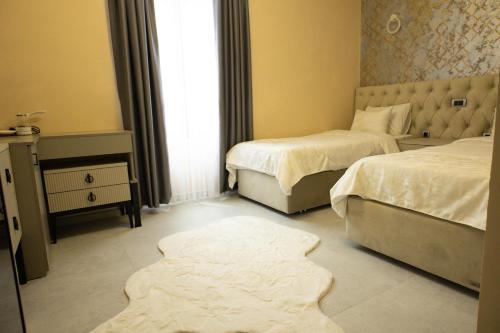 a bedroom with two beds and a rug on the floor at All Elevens 11 Apartments in Bitola