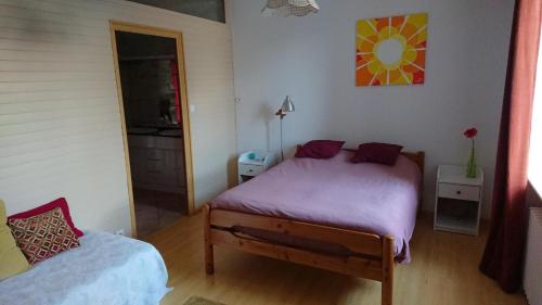 - une chambre dotée d'un lit avec des draps violets dans l'établissement Chambre d'hôte au pays des abers, à Lannilis