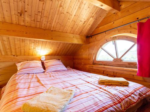 Ce lit se trouve dans une chambre en bois dotée d'une fenêtre. dans l'établissement Chalet Le Chamalo by Interhome, à Barneville-Plage