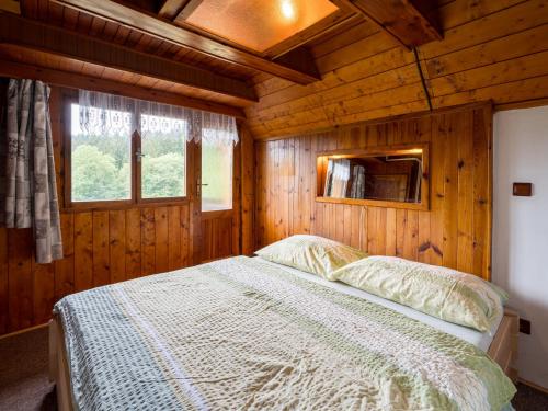 a bedroom with a bed in a wooden cabin at Chalet Mrklov by Interhome in Mrklov