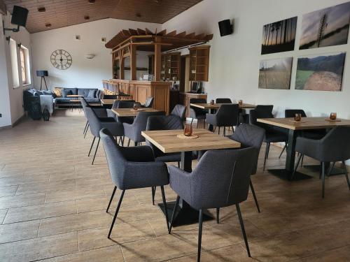 a restaurant with tables and chairs in a room at Penzion Kostelany 