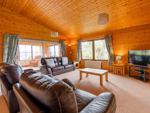 a living room with leather furniture and a flat screen tv at Holiday Home Achmony Type 2-1 by Interhome in Drumnadrochit