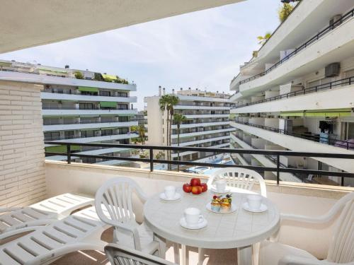 uma mesa branca e cadeiras numa varanda com edifícios em Apartment Riviera Park-7 by Interhome em Salou