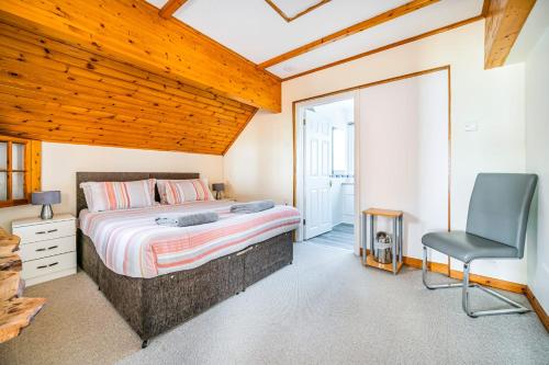 een slaapkamer met een bed, een bureau en een stoel bij Beachfront Escape Sleeps 8 Ideal Family Retreat in Pevensey