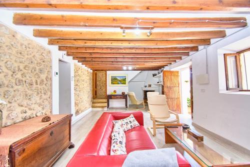 a living room with a red couch and wooden ceilings at Villa Son Bennassar in Inca