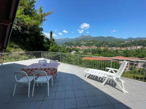 a table and chairs on a balcony with a view at Appartamento Ai Rododendri in Pray