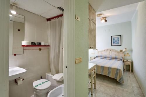 a bathroom with a sink toilet and a bed at Hotel Zaymar in Castellón de la Plana