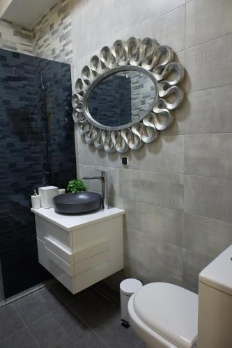 a bathroom with a sink and a mirror on the wall at All Elevens 11 Apartments in Bitola