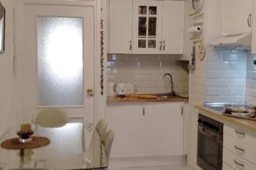 a kitchen with white cabinets and a table in it at Old town Marbella home in Marbella