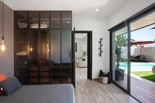 een woonkamer met een glazen deur die naar een zwembad leidt bij Villa Toro in Corralejo