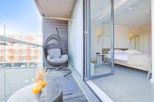 a room with a balcony with a bed and a swing at Bluetique Studio of Palanga in Palanga