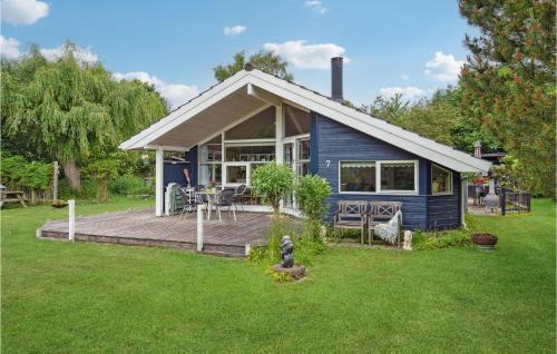 a blue house with a deck in a yard at Lovely Home In Faxe Ladeplads With Wifi in Fakse Ladeplads