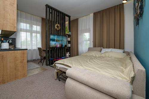 a bedroom with a large bed and a kitchen at Vila Kollár Apartmán 2 in Vysoke Tatry - Dolny Smokovec