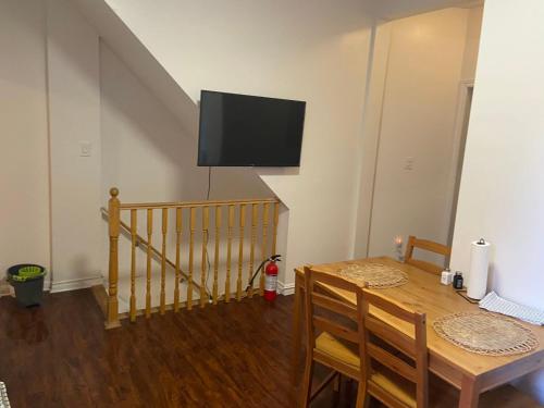 a dining room with a table and a television on the wall at Triple Room with En Suite Bathroom 0361 in Toronto