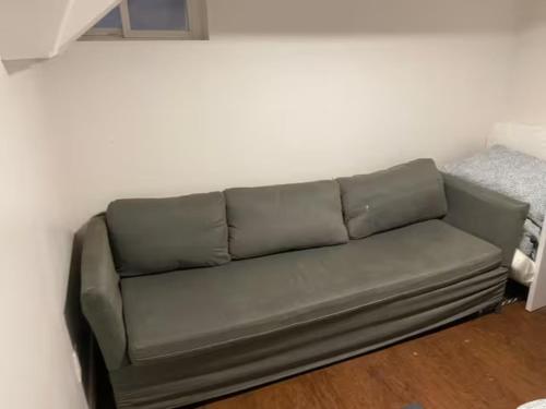 um sofá verde sentado numa sala de estar em Private Basement Room 0363 em Toronto